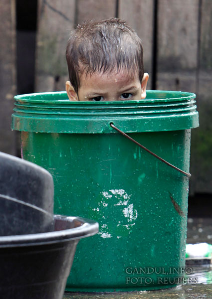 A boy is seen inside a bucket as he takes a bath at a slum area in Tondo, Metro Manila January 24, 2009. REUTERS/John Javellana (PHILIPPINES)
